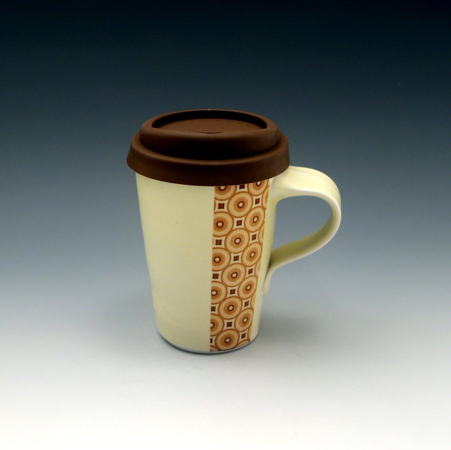 Creamy yellow glazed porcelain travel mug with circle pattern and silicone lid